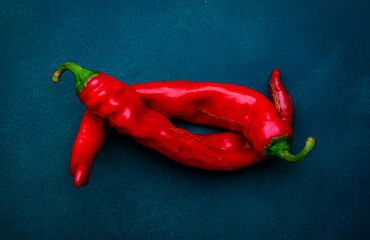 Food art. Red chili pepper on deep blue background, minimalism style, top view