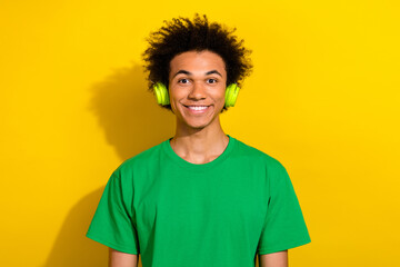 Sticker - Photo of cheerful positive guy dressed green t-shirt headphones enjoy music emtpy space isolated yellow color background