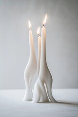 Wall Mural -   A pair of white candles rest atop a white table, adjacent to a white wall