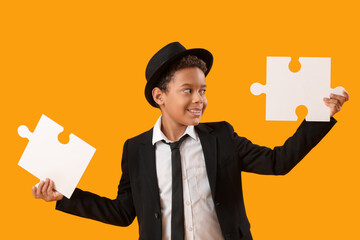 Poster - Little African-American boy with jigsaw puzzles on yellow background