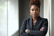 © wolfhound911 - A fierce African American woman in a blazer and dress pants, standing with arms crossed and an intense look, embodying strength and authority in her workplace.