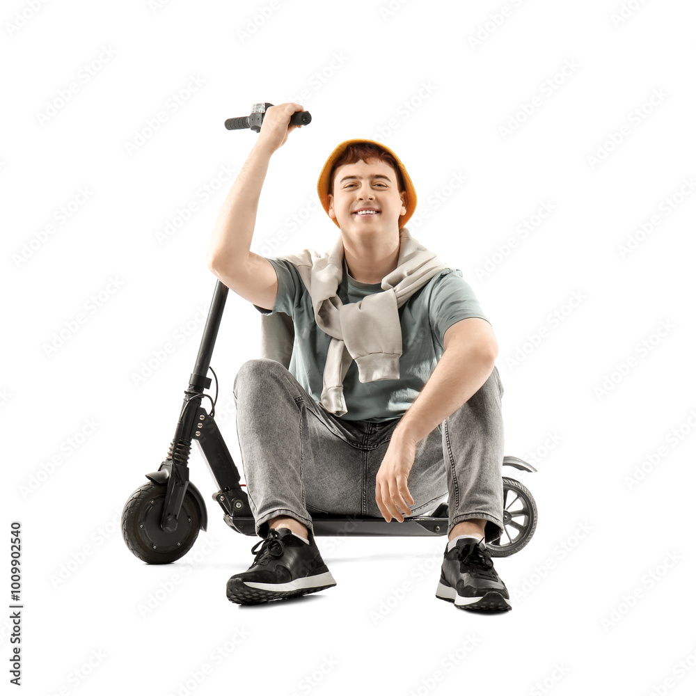 Happy young man with modern electric kick scooter sitting against white background