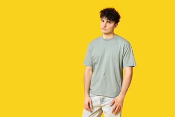 Wall Mural - Handsome young man in stylish t-shirt on yellow background