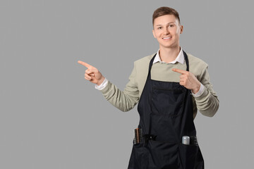 Poster - Male barber pointing at something on grey background