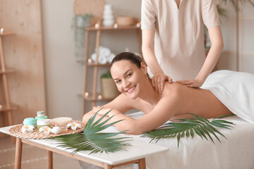 Canvas Print - Happy young woman getting back massage in spa salon