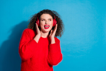 Wall Mural - Photo of attractive young woman headphones listen music look empty space dressed stylish red clothes isolated on blue color background