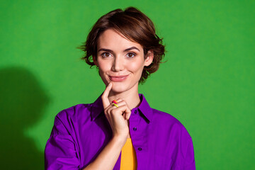 Poster - Portrait photo of young thoughtful young lady in purple shirt touch chin cunning serious planning isolated on green color background