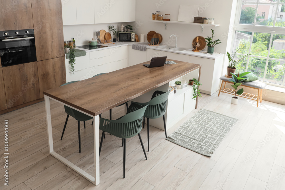 Interior of dining room with table,  counters and houseplants near white wall