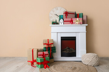 Poster - Fireplace with Christmas presents and pouf near beige wall in room