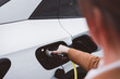 © VisualProduction - Close-up of a businesswoman plugging in an electric car charger at a public charging station