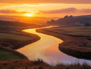 Wall Mural - A winding river flows through a valley as the sun sets behind the hills, casting a golden glow on the water.