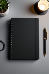 Top view of a black notebook places on a desk with decor elements, vertical composition