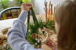 © Franci Leoncio - Woman holding a handmade Christmas wreath with natural decor