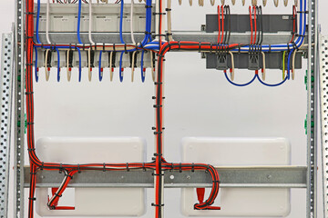 Connecting electrical modules using insulated wires in an electrical distribution cabinet. Close-up.