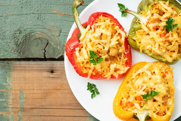 Baked stuffed pepper ( paprika ) with rice , carrot and meat . Top view on rustic background