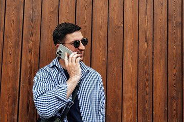 man in sunglasses smiling while talking on his phone