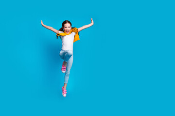 Wall Mural - Photo of cheerful pretty little lady dressed tied jumper jumping high flying empty space isolated blue color background