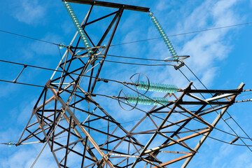 High voltage power line on blue sky background in Sunny day. wires, problems with electricity, power transmission. power line construction of cable supports and insulators. blackout, crisis