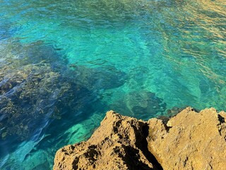 Canvas Print - Rocky coast and emerald blue sea.