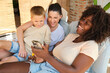 © ADDICTIVE STOCK - Multiracial family enjoying time together with smartphone