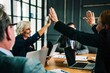 © Svyatoslav Lypynskyy - A businesswoman enthusiastically high fives a male colleague, capturing a moment of teamwork and success in a lively boardroom meeting among colleagues.