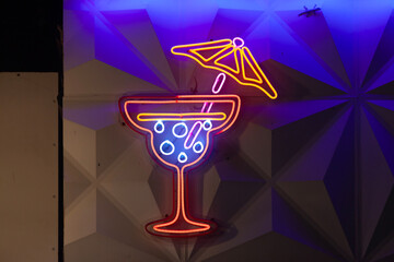 A neon sign outside of a Cocktail Bar shaped like a cocktail glass.