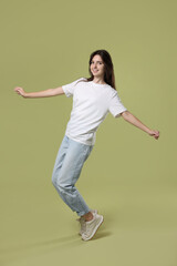 Poster - Cheerful teenage girl dancing on olive background