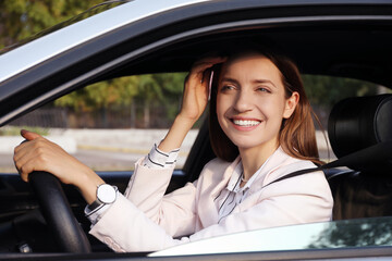 Wall Mural - Woman holding steering wheel while driving car