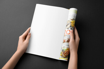 Poster - Woman reading magazine on black background, closeup. Mockup for design