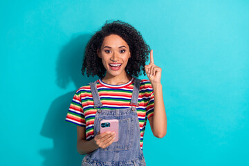 Wall Mural - Photo of amazed girl hold cell smart device have idea point finger isolated cyan color background