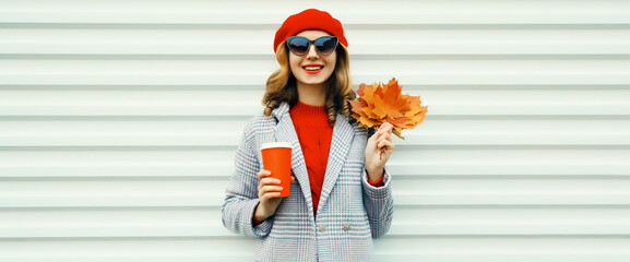 Wall Mural - Autumn portrait of beautiful smiling young woman with yellow maple leaves, cup of coffee drink