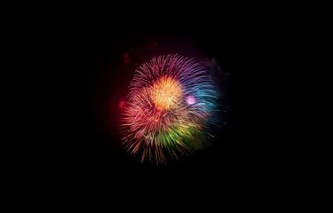 A colorful firework display explodes in the night sky, with streaks of red, orange, yellow, green, blue, and purple.