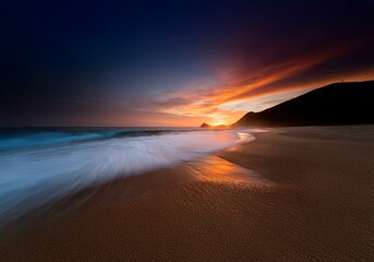 Poster - A beach at sunset, with waves lapping at the shore and a fiery sky above.