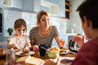 © Geber86 - Mother eating breakfast with her kids on kitchen table