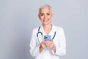 Wall Mural - Photo of pretty lovely attractive professional doctor surgeon woman wear white coat hold device isolated on grey color background