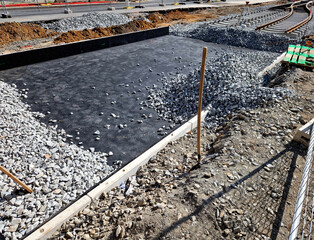 new and precise laying of tracks using leveling devices at the fork in two tram tracks. a layer of gravel above which concrete sleepers are placed. rubber anti-vibration base made of rubber