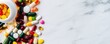 © Narongsak - An array of colorful capsules, tablets, and soft gels scattered on a marble surface, showcasing a variety of dietary supplements and medications for health and wellness.