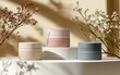 © Wan - Elegant cosmetic jars in soft pastel colors displayed with delicate dried flowers, creating a serene and minimalistic beauty scene.