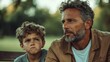 © svastix - A sincere father and son sit pensively on a park bench, captured in a profound moment of thought and connection under the soft daylight in a serene environment.
