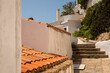 © vegefox.com - A winding cobblestone path leads up to a white building in a sun drenched Greek town