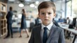 © Dmitry - A young boy dressed in a smart suit exudes confidence amid a bustling office with adults engaged in various tasks, showcasing ambition and poise