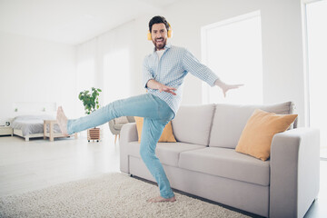 Canvas Print - Photo of handsome bearded alone mature age man staying home dance boogie woogie style with headphones in his new house indoors