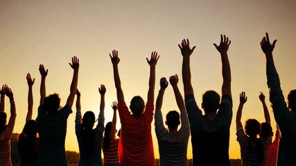 Poster - A group of people are standing in a field with their hands raised in the air