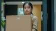 © Art Fusion - Unemployed, quitting job. Desperate asian young businesswoman resigning from company, putting belongs, pack stuff in cardboard box, layoff or leaving, changing work. Resignation, employment concept.