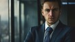 © VK Studio - A businessman stands in front of a modern glass building, his confident posture and serious expression reflecting authority and leadership in an urban setting.