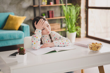 Wall Mural - Photo of cute small schoolgirl bored read book desk think wear pullover modern interior apartment indoors