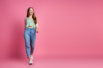 Wall Mural - Full body portrait of pretty young girl walk look empty space wear top isolated on pink color background