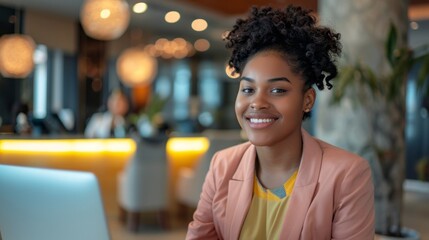 Poster - A woman with a smile on her face is sitting in front of a laptop