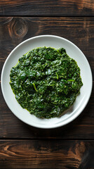 Beautiful presentation of sauteed chopped kale on a white plate, set on a rustic wooden table, offers a visually appealing and healthy vegetarian meal option