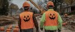© Kittipong - Festive Halloween Construction Workers with Jack-O'-Lantern Vests Walking on Dirt Site